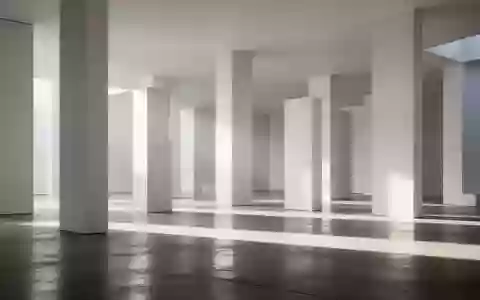 Minimalistisches, modernes Architektur-Interieur mit geometrischen Säulen und weichem Lichteinfall auf einem Betonboden. - Foto: über boerse-global.de