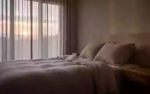 Ein minimalistisches, ruhiges Schlafzimmer bei natürlichem Licht, das eine Atmosphäre der Erholung und Entspannung ausstrahlt. - Foto: über boerse-global.de