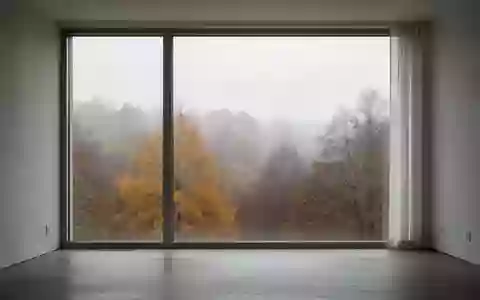 Ein minimalistischer Raum mit einem großen Fenster, durch das gedämpftes herbstliches Tageslicht fällt. - Foto: über boerse-global.de