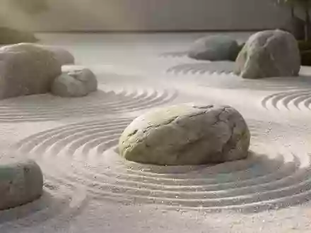 Minimalistischer Zen-Garten mit geharktem Sand und glatten Flusskieselsteinen in sanftem Morgenlicht. - Foto: über boerse-global.de