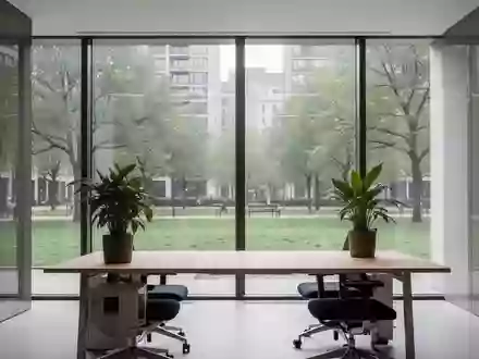 Ein minimalistischer, heller Büroarbeitsplatz mit Blick auf eine Grünanlage, ohne Personen oder technische Geräte. - Foto: über boerse-global.de