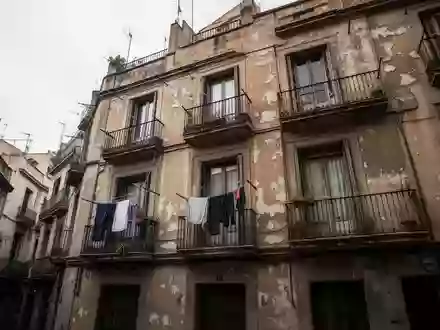 Fassade eines alten Wohnhauses in einem dicht besiedelten Viertel von Barcelona bei bewölktem Tageslicht. - Foto: über boerse-global.de