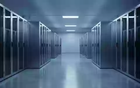 Ein moderner, minimalistischer Serverraum mit kühler blauer Beleuchtung und symmetrisch angeordneten, neutralen Metallschränken. - Foto: über boerse-global.de