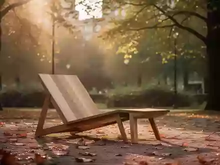 Eine hölzerne Liege in einer ruhigen Parkanlage bei goldenem Herbstlicht, die zu einer bewussten Auszeit einlädt. - Foto: über boerse-global.de