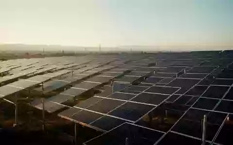 Reihen von Photovoltaikmodulen in einem Solarpark bei Sonnenuntergang. - Foto: über boerse-global.de