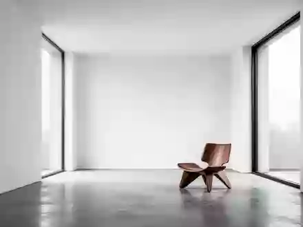 Ein minimalistischer, moderner Raum mit klaren weißen Wänden und natürlichem Licht, das durch ein großes Fenster fällt. - Foto: über boerse-global.de