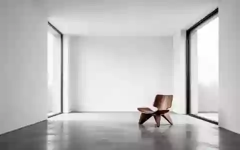 Ein minimalistischer, moderner Raum mit klaren weißen Wänden und natürlichem Licht, das durch ein großes Fenster fällt. - Foto: über boerse-global.de