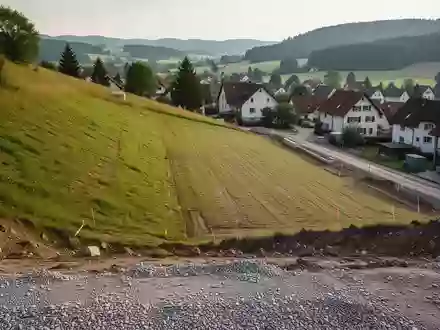 Eine unbebaute, abschüssige Baufläche an einem Hang in Adenau, vorbereitet für zukünftige Baumaßnahmen. - Foto: über boerse-global.de