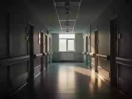 Ein ruhiger, menschenleerer Krankenhausflur im fahlen Licht des Morgengrauens, der die Atmosphäre der Arbeitsbelastung reflektiert. - Foto: über boerse-global.de
