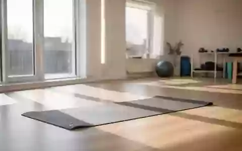 Ein heller, minimalistischer Physio-Raum mit einer Yoga-Matte auf dem Holzboden in einer ruhigen, sonnendurchfluteten Umgebung. - Foto: über boerse-global.de