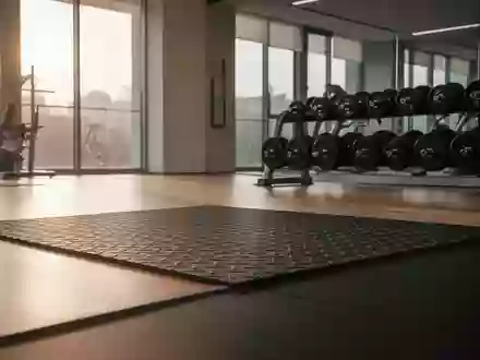 Ein minimalistisch gestalteter Fitnessraum mit hochwertigen Trainingsgeräten und weichem Tageslicht auf dem Boden. - Foto: über boerse-global.de