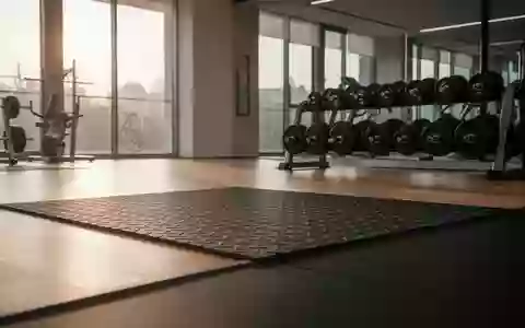 Ein minimalistisch gestalteter Fitnessraum mit hochwertigen TrainingsgerĂ€ten und weichem Tageslicht auf dem Boden. - Foto: ĂŒber boerse-global.de