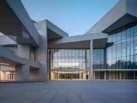 Ein modernes, minimalistisches Regierungsgebäude bei Dämmerung mit klaren architektonischen Linien und einer leeren Plaza. - Foto: über boerse-global.de