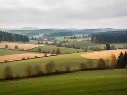 Landschaftsaufnahme mit sanften Hügeln und herbstlichen Feldern in Bayern bei diffusem Tageslicht - Foto: über boerse-global.de