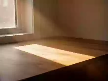 Ein heller Lichtstrahl fällt durch ein Fenster in einen minimalistisch gestalteten Raum und symbolisiert die Bedeutung von Sonnenlicht. - Foto: über boerse-global.de