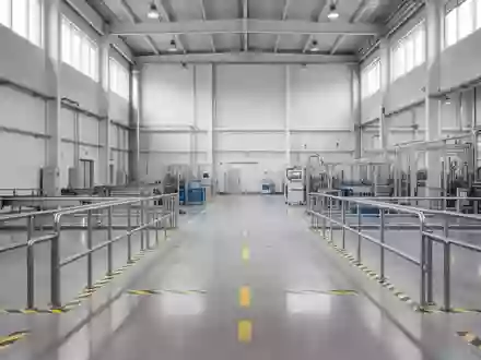 Ein moderner, sauberer Industriebereich mit Sicherheitsmarkierungen auf dem Boden und Metallgeländern in einer Produktionshalle. - Foto: über boerse-global.de