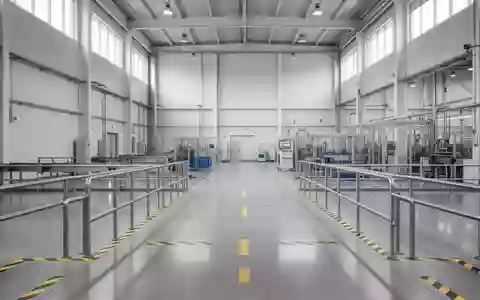 Ein moderner, sauberer Industriebereich mit Sicherheitsmarkierungen auf dem Boden und Metallgeländern in einer Produktionshalle. - Foto: über boerse-global.de