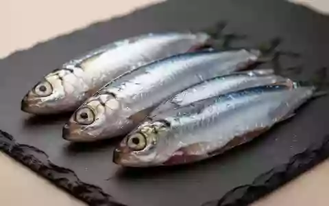 Frische Sardinen auf einer dunklen Schieferplatte, die die natürliche Quelle von Omega-3-Fettsäuren verdeutlichen. - Foto: über boerse-global.de