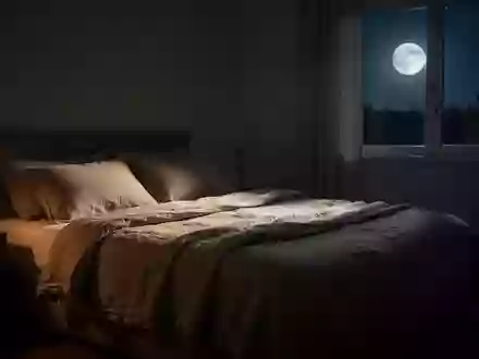Ein minimalistisch eingerichtetes, nächtliches Schlafzimmer mit weicher Bettwäsche und sanftem Mondlicht. - Foto: über boerse-global.de