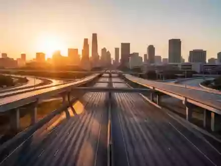 Eine weitläufige, moderne Autobahnkreuzung in einer US-Großstadt während des Sonnenuntergangs. - Foto: über boerse-global.de