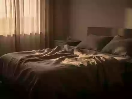 Ein ungemachtes Bett in einem ruhig beleuchteten Schlafzimmer bei Tagesanbruch, das eine Atmosphäre der Einsamkeit und Ruhe vermittelt. - Foto: über boerse-global.de