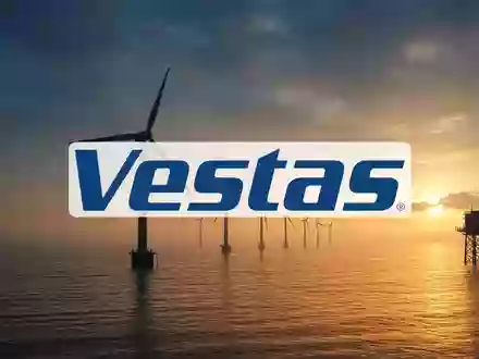 Moderne Windkraftanlagen in einer weiten Küstenlandschaft während des Sonnenuntergangs. - Foto: über boerse-global.de