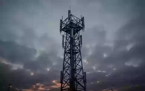 Ein Funkturm steht einsam vor einem bewölkten Abendhimmel als Symbol für die Mobilfunkinfrastruktur. - Foto: über boerse-global.de