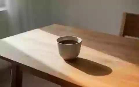 Eine schlichte Keramiktasse mit dunklem Kaffee auf einem Holztisch in hellem, natürlichem Tageslicht. - Foto: über boerse-global.de