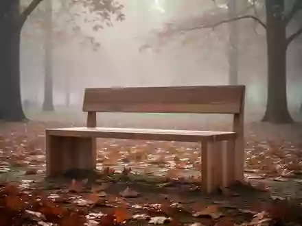Eine leere Holzbank in einem nebligen Herbstpark mit herabgefallenem Laub am Boden. - Foto: über boerse-global.de