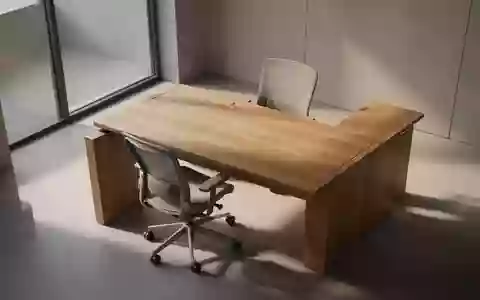Ein minimalistischer, leerer Büroarbeitsplatz mit einem Holztisch und einem ergonomischen Stuhl in natürlichem Licht. - Foto: über boerse-global.de