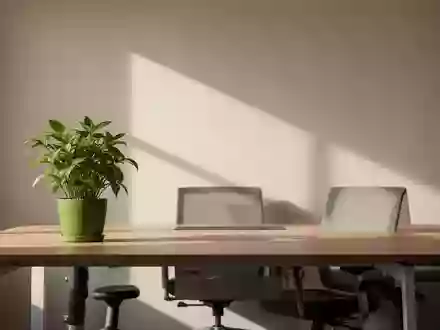 Ein leerer, sonnendurchfluteter Arbeitsplatz mit einer Pflanze auf einem Holztisch in einer ruhigen, minimalistischen Büroumgebung. - Foto: über boerse-global.de
