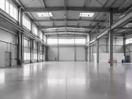 Leere, moderne Industriehalle mit polierten Betonböden und Stahlelementen in neutralem Licht. - Foto: über boerse-global.de