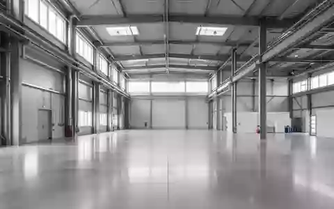 Leere, moderne Industriehalle mit polierten Betonböden und Stahlelementen in neutralem Licht. - Foto: über boerse-global.de