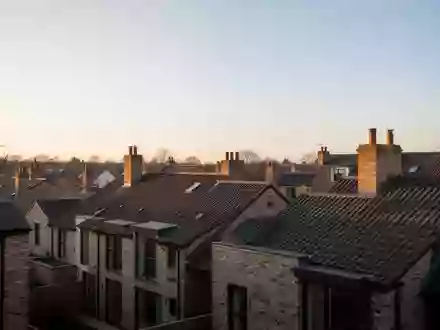 Wohnviertel mit Wohnhäusern und Schornsteinen bei Sonnenuntergang. - Foto: über boerse-global.de