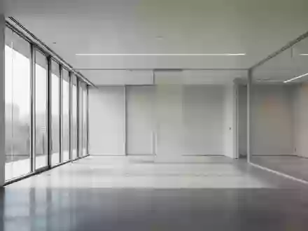Ein minimalistischer, lichtdurchfluteter moderner Büroraum mit neutralen Wänden und poliertem Betonboden ohne Personen. - Foto: über boerse-global.de