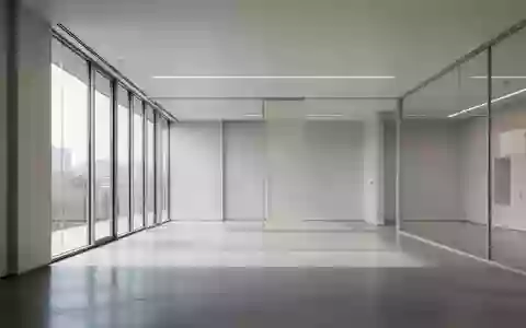 Ein minimalistischer, lichtdurchfluteter moderner Büroraum mit neutralen Wänden und poliertem Betonboden ohne Personen. - Foto: über boerse-global.de