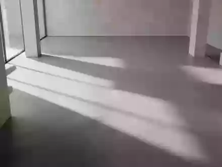 Ein minimalistischer, moderner Innenraum mit geometrischen Schatten auf einem polierten Betonboden. - Foto: über boerse-global.de