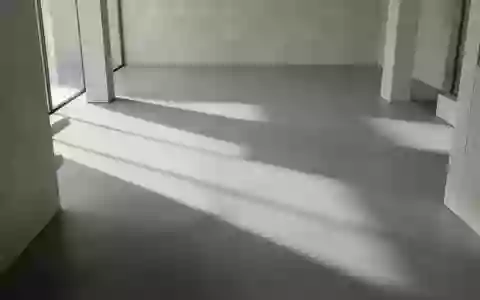 Ein minimalistischer, moderner Innenraum mit geometrischen Schatten auf einem polierten Betonboden. - Foto: über boerse-global.de