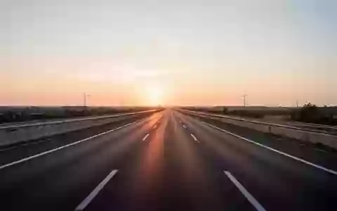 Eine leere, moderne Autobahn bei Sonnenuntergang, die den Übergang zur automatisierten Mobilität symbolisiert. - Foto: über boerse-global.de