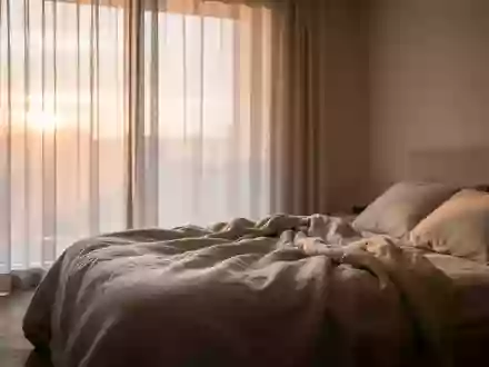 Ein ungemachtes Bett in einem minimalistischen Schlafzimmer in den frühen Morgenstunden mit weichem Tageslicht. - Foto: über boerse-global.de