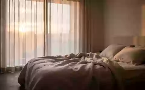 Ein ungemachtes Bett in einem minimalistischen Schlafzimmer in den frühen Morgenstunden mit weichem Tageslicht. - Foto: über boerse-global.de