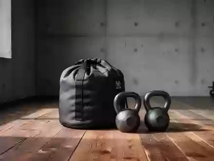 Ein minimalistischer Fitnessraum mit einem Sandsack und zwei Kettlebells auf einem Holzboden bei natürlichem Lichteinfall. - Foto: über boerse-global.de