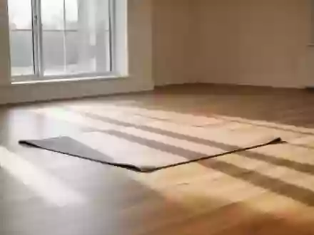 Ein heller, minimalistischer Übungsraum mit einem einzelnen Trainingsmatten-Bereich auf einem Holzboden in ruhigem Licht. - Foto: über boerse-global.de