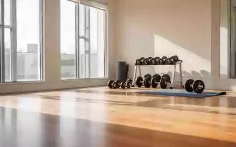 Heller, moderner Fitnessraum mit Hanteln und einer Yogamatte auf einem Holzboden. - Foto: über boerse-global.de