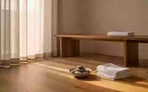 Ein minimalistischer, heller Raum mit einer Holzbank, einem Tuch und glatten Flusskieselsteinen in ruhiger Atmosphäre. - Foto: über boerse-global.de