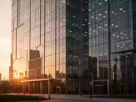 Moderne Glasfassade eines Bürogebäudes während der goldenen Stunde. - Foto: über boerse-global.de