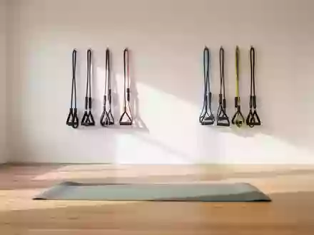 Ein heller, minimalistischer Trainingsraum mit einer Gymnastikmatte und Widerstandsbändern an einer weißen Wand. - Foto: über boerse-global.de