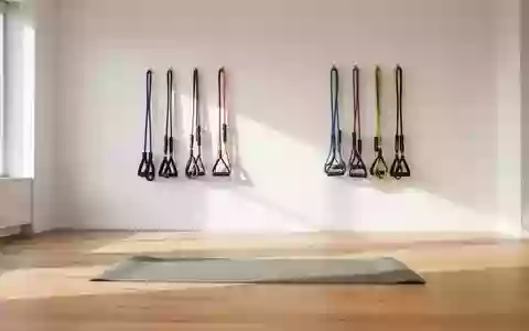 Ein heller, minimalistischer Trainingsraum mit einer Gymnastikmatte und Widerstandsbändern an einer weißen Wand. - Foto: über boerse-global.de