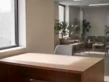 Ein minimalistisch eingerichtetes, helles Arztzimmer mit einem leeren Schreibtisch und einer ruhigen Atmosphäre. - Foto: über boerse-global.de