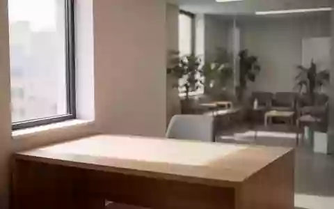 Ein minimalistisch eingerichtetes, helles Arztzimmer mit einem leeren Schreibtisch und einer ruhigen Atmosphäre. - Foto: über boerse-global.de
